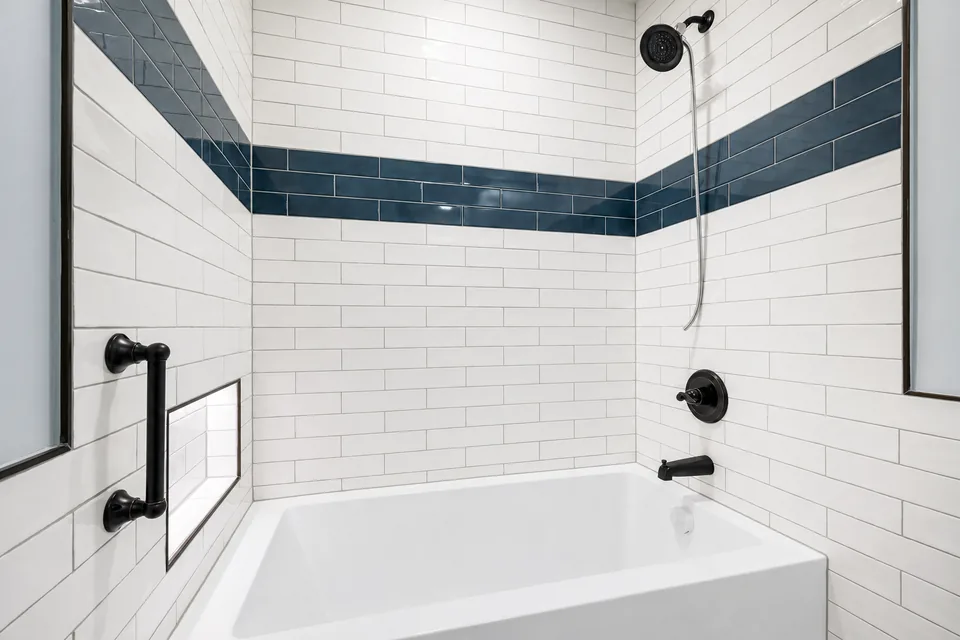 Completed CT Builders white tiled bathroom with dark accent tiles